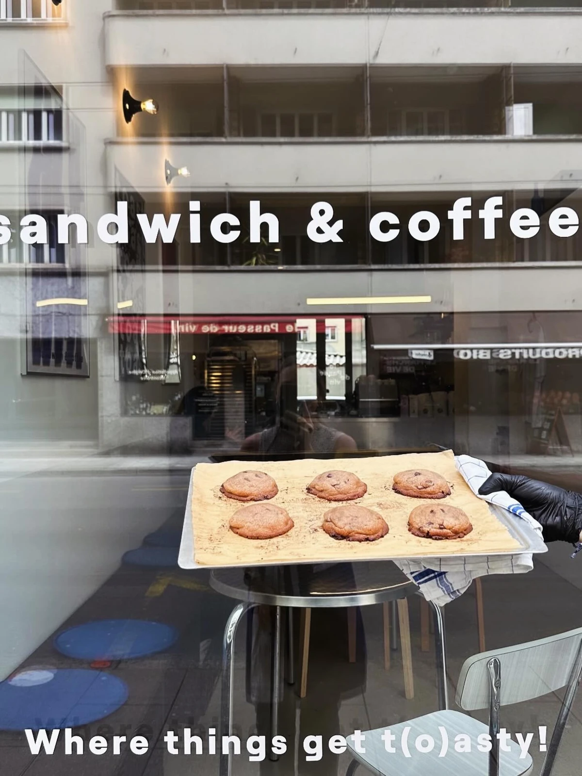 Plateau de cookies derrière la vitrine, lettrage sandwich & coffee